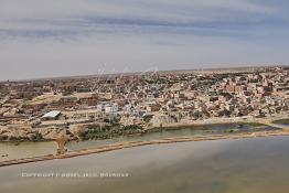 Image du Maroc Professionnelle de  Cette vue aérienne de la ville de Laayoune nous découvre au premier plan le fleuve la Sakia Al Hamra juste derrière protégé par une digue la partie stagnante des égouts à ciel ouvert, malgré tous les investissements la ville manque cruellement d'une station de pompage et d'une station de traitement des eaux usées, le 9 Avril 2010. (Photo / Abdeljalil Bounhar) 